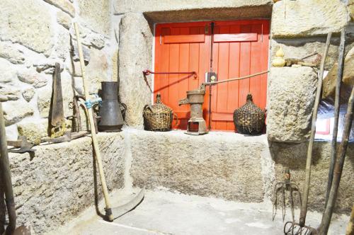 a group of vases on a ledge in front of a red door at Casa de Campo das Sécias in Vilas Boas
