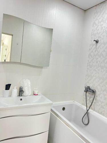 a white bathroom with a sink and a tub at Полноценная двухкомнатная квартира в престижном районе, мкр Батыс-2 in Aktobe