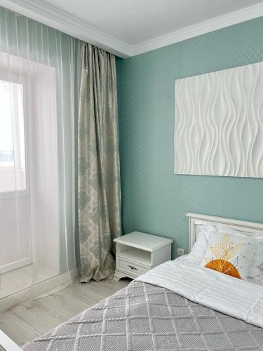 a bedroom with a bed and a window at Полноценная двухкомнатная квартира в престижном районе, мкр Батыс-2 in Aktobe