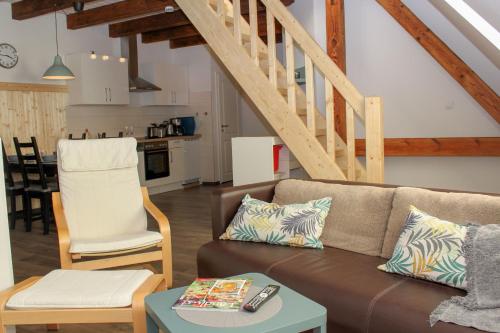 a living room with a couch and a staircase at Ferienwohnung Helmsstraße II in Ebstorf