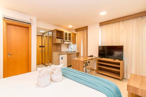 a hotel room with a bed and a flat screen tv at Saint Moritz Hotel em Brasília 63939 in Brasilia