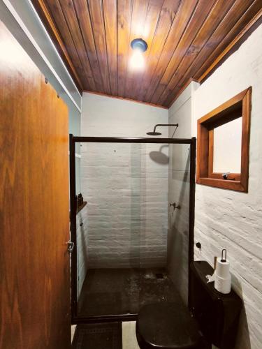 a bathroom with a glass shower with a toilet at Cabanas All Black in Monte Verde