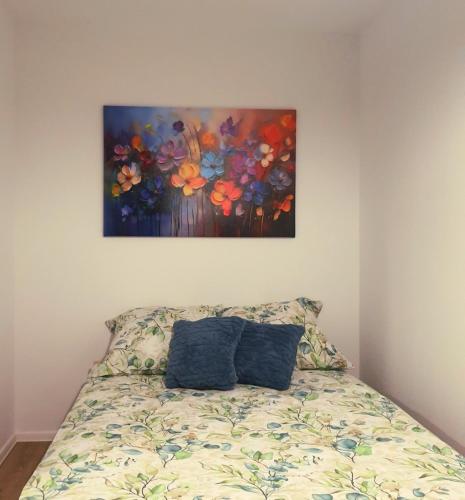 a bedroom with a bed with a painting on the wall at Apartament blu in Piece
