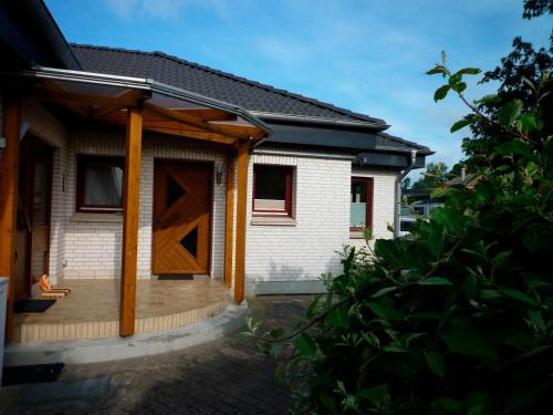 a house with a wooden door and a porch at KoppelBlick in Vadersdorf