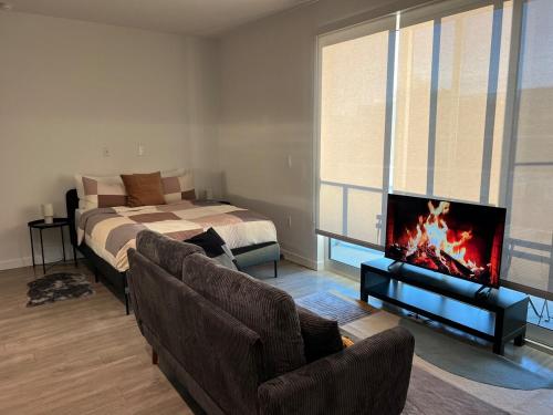 a living room with a bed and a couch and a tv at Santa Monica Bright Studio with stunning view in Los Angeles