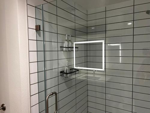 a bathroom with a glass shower with a mirror at Santa Monica Bright Studio with stunning view in Los Angeles