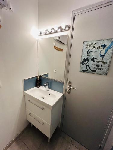 une salle de bain avec un lavabo et un miroir dans l'établissement EStudio 1ère ligne vue mer ,place de parking privée accès a la plage de la résidence 3ème étage, à Palavas-les-Flots