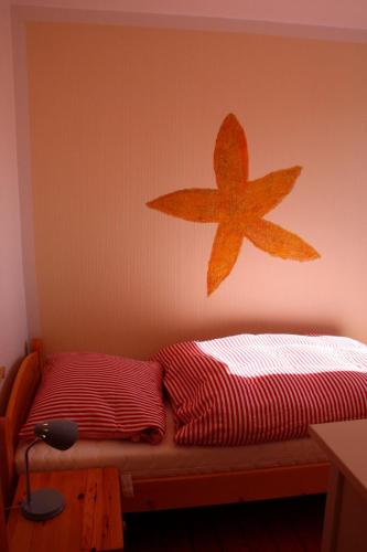 a bedroom with a bed with a star on the wall at Ferienwohnung "Seestern" in Hinrichsdorf