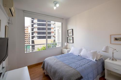 a white bedroom with a bed and a window at Luxury 1 Bedroom Las Cañitas! Fast Wi-Fi! Pool ! in Buenos Aires