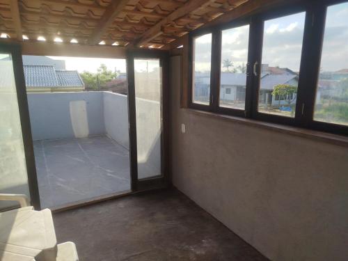 an empty room with windows in a building at Sobrado São Chico, Ubatuba SFS in São Francisco do Sul