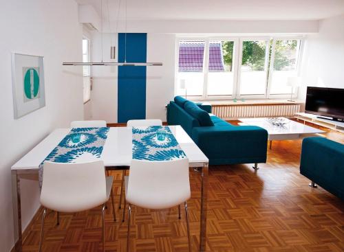 a living room with a table and chairs and a couch at Ferienwohnung "himmelblau" in Fehmarn