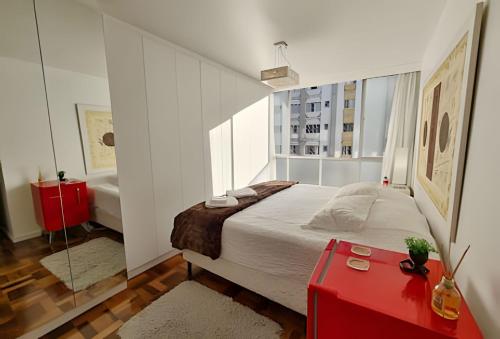 a bedroom with a large bed and a red trunk at Conforto e espaço para família, 3 Quartos, Garagem in Curitiba