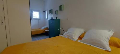 - une chambre avec un lit jaune et 2 oreillers dans l'établissement Villa 
