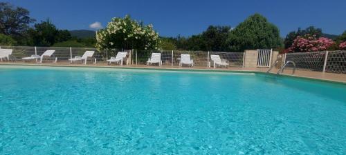 - une piscine avec des chaises blanches dans l'établissement Villa 