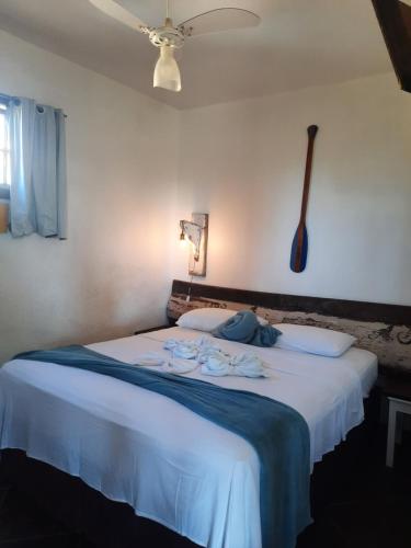 a bedroom with a large white bed with a ceiling at Pousada Icthus in Cabo Frio