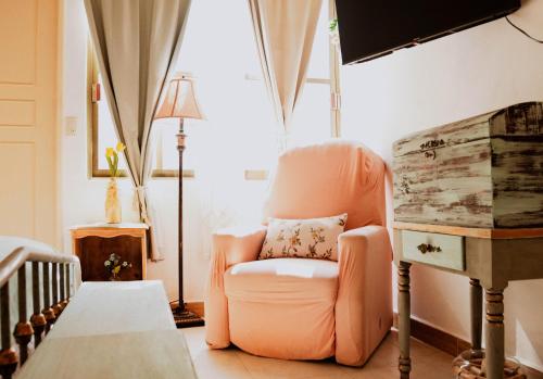 a living room with an orange chair and a lamp at Freijoó Casa Vintage in Papantla de Olarte