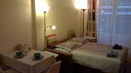 a small bedroom with a bed and two tables at Studio Carré d'Or, à 50 m de la plage et du Négresco in Nice