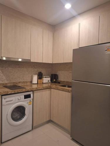 a kitchen with a washer and a dishwasher at Cozy Beach & Pra Tamnak Condo Pattaya in Pattaya South