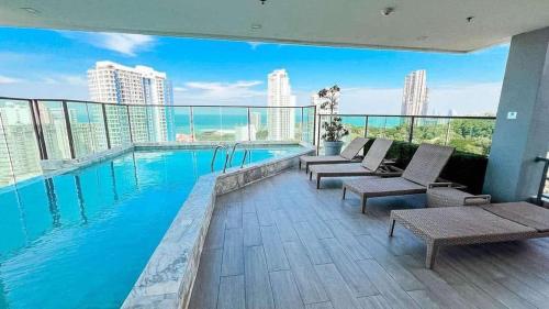 a swimming pool with a view of a building at Cozy Beach & Pra Tamnak Condo Pattaya in Pattaya South