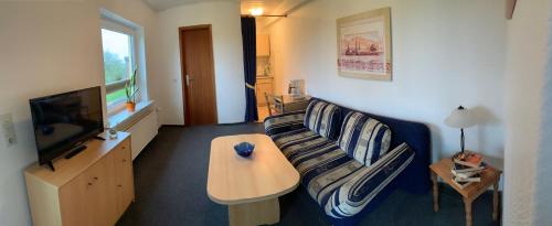 un soggiorno con un divano e una TV di "Ferienhof Alte Mühle" M 1 a Bannesdorf