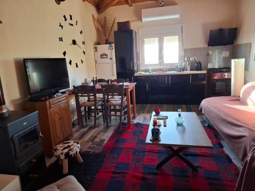 a living room with a table and a kitchen at zikos house in Monemvasia