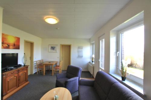 un salon avec un canapé, une télévision et une table dans l'établissement "Ferienhof Alte Mühle" W 3, à Bannesdorf