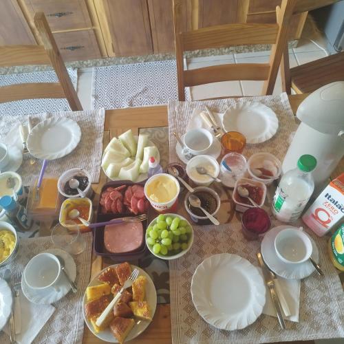 ein Tisch mit Tellern voller Essen darauf in der Unterkunft Casa suíça suíte nr3 master luxo 4-pessoas in Pomerode