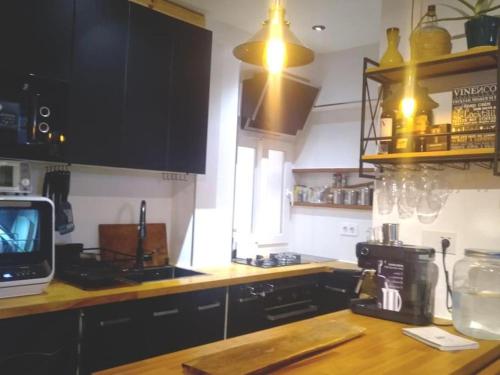 a kitchen with black cabinets and a counter top at Loft PLAYA -60m- & TRABAJO -online- in Almería