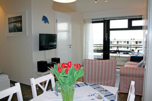 a living room with a table with a vase of flowers on it at Meeresrauschen in Staberdorf