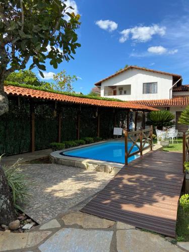 a backyard with a swimming pool and a house at Pousada das Orquídeas in Pirenópolis
