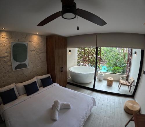 a bedroom with a large bed and a bath tub at Jade Tulum Zen Residences 22 in Tulum