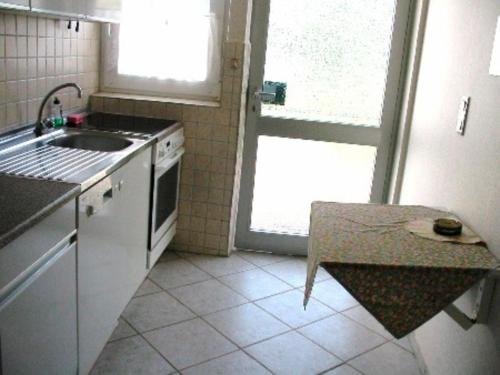 a small kitchen with a sink and a stove at Ferienhof Jahn - Appartment in Westfehmarn
