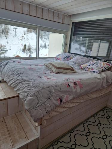 un grand lit dans une chambre avec une fenêtre dans l'établissement appartement pendine 1 plein sud 53m2, à Puy-Saint-Vincent