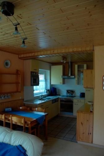a kitchen with wooden ceilings and a table in a room at Ferienwohnung Cantay - Nr 2 in Fehmarn