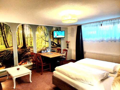 a bedroom with a bed and a table and a tv at CariSSA Ferienwohnung - mit THERMEplus in Bad Bevensen