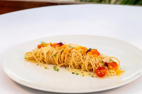 a white plate of pasta with tomatoes and sauce at Live Aqua Cancun - Adults Only - All-Inclusive in Cancún
