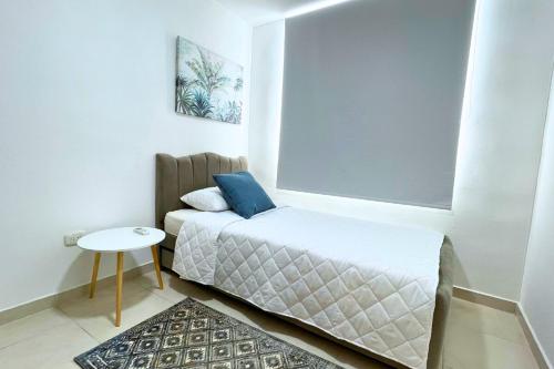 a small bedroom with a bed and a small table at Apartmento En Miramar in Barranquilla