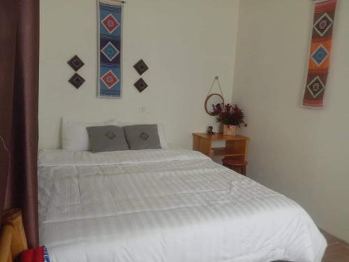 a bedroom with a large white bed with two pillows at Mộc Nhiên Homstay Mai Chau in Hòa Bình