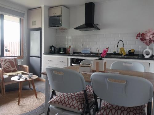 a kitchen with a table and chairs and a kitchen with a counter at Departamento in Punta Arenas