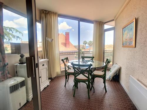 une salle à manger avec une table et des chaises et une fenêtre dans l'établissement A 2 pas des plages du Midi, terrasse, 252L-BOU, à Cannes