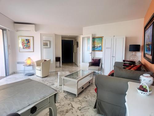 un salon avec un canapé et une table dans l'établissement A 2 pas des plages du Midi, terrasse, 252L-BOU, à Cannes