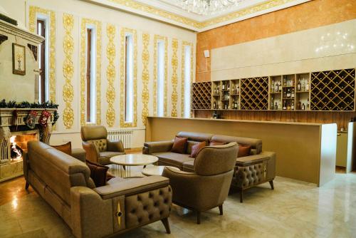 a living room with couches and chairs and a fireplace at Olive Garden Baku Hotel in Baku