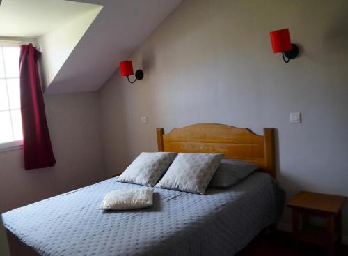 une chambre avec un lit avec deux oreillers dessus dans l'établissement La résidence du Lac - maeva Home - Maison 2 pièces 5 personnes - Prestige MAE-4734, à Monflanquin