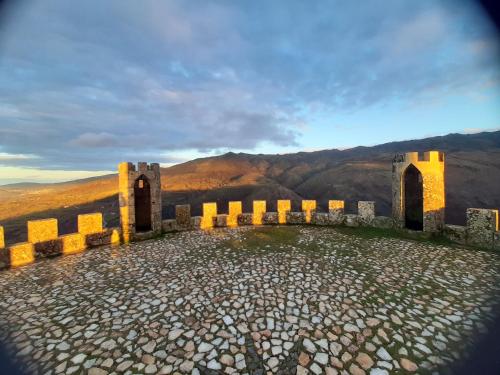 a view of a castle with mountains in the background at Casa da Tia Lurdes in Folgosinho