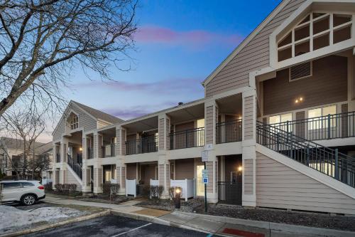 an apartment building with a car parked in a parking lot at Avia Residences on Lincoln - Extended Stay in Malvern