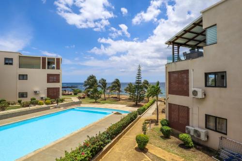 フリック・アン・フラックにあるBeachfront Heaven Apartment Flic en Flac 3の建物の隣にスイミングプール付きのアパートメント