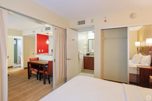 a hotel room with a bed and a desk and a kitchen at Avia Residences on Research - Extended Stay in Westborough