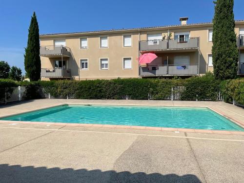 - une piscine en face d'un immeuble dans l'établissement Appartement rez de jardin, au Pontet