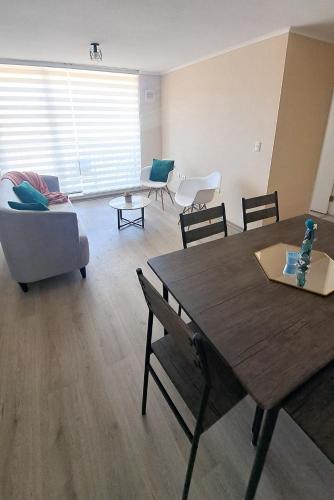 a living room with a table and a couch at Departamento con vista al Volcán in Villarrica