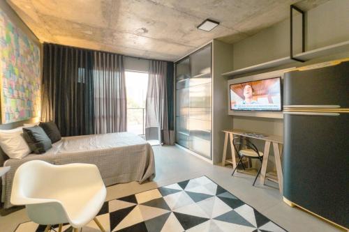 a bedroom with a bed and a tv on a wall at Apartamento Centro Moderno CA403 in Maringá